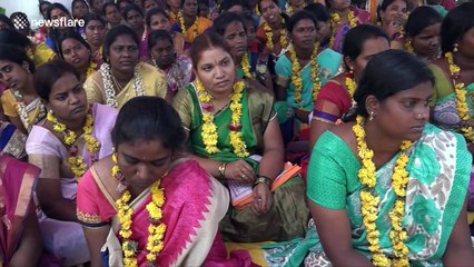 Indian women eat from the floor with hands behind back in bizarre fertility ritual