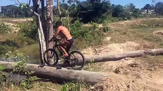 Ce cycliste se rate complètement en traversant une rivière en vélo sur un tronc d'arbre...