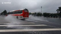 Cars create beautiful water waves when driving through flooded road