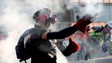 خاموش کردن گاز اشک‌آور با بطری آب در هنگ‌کنگ