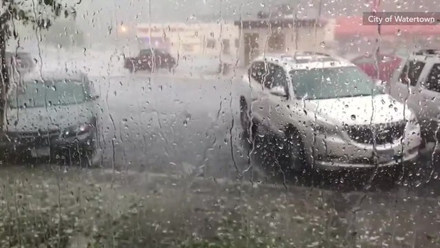 Hail plummets into the ground battering standing vehicles