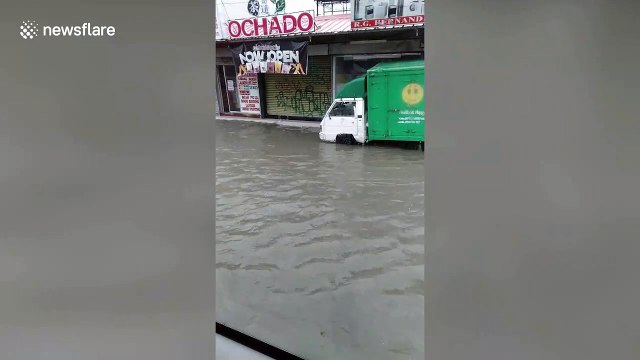 Pedestrians wade through flood water in the Philippines