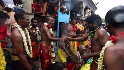 Smashing it! Devotees line up to have coconuts broken on their heads in traditional Indian festival