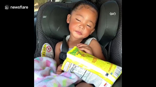 Precious toddler tries her best to stay awake while eating snacks