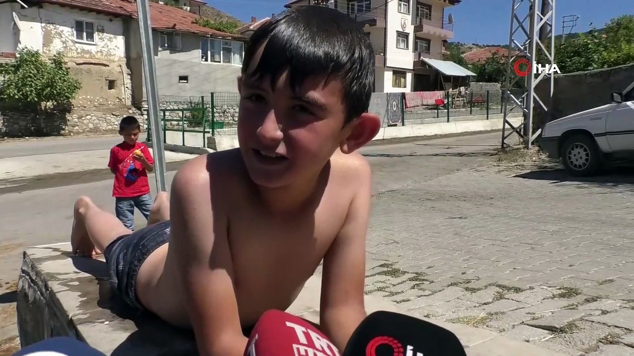 Çocuklar çeşme oluğunda yüzerek serinledi