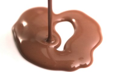 Melted chocolate pouring onto white surface