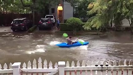 Il fait du kayak dans une rue inondée