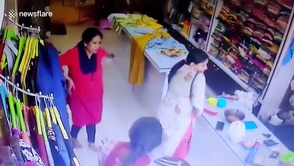 Two bulls crash through shop window during street fight in India, terrifying customers