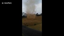 Fearless kids run into massive dust devil in Indonesia