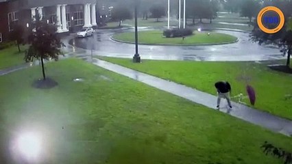 Un éclair s'abat sur le parapluie que tient cet homme pour se protéger de la pluie !