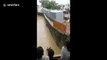 Dramatic moment shops on river edge collapse and get washed away in central Indian floods