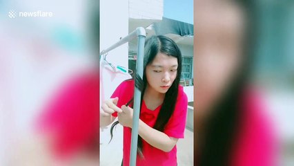 Chinese girl uses a hot outdoor water pipe to curl her hair