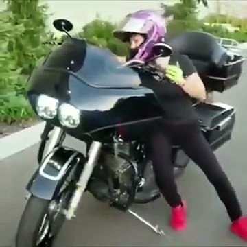 Cette jeune fille fait un wheeling avec une grosse moto cylindrée