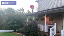 Un homme saute de son porche avec un parapluie  comme Mary Poppins et tombe lourdement au sol