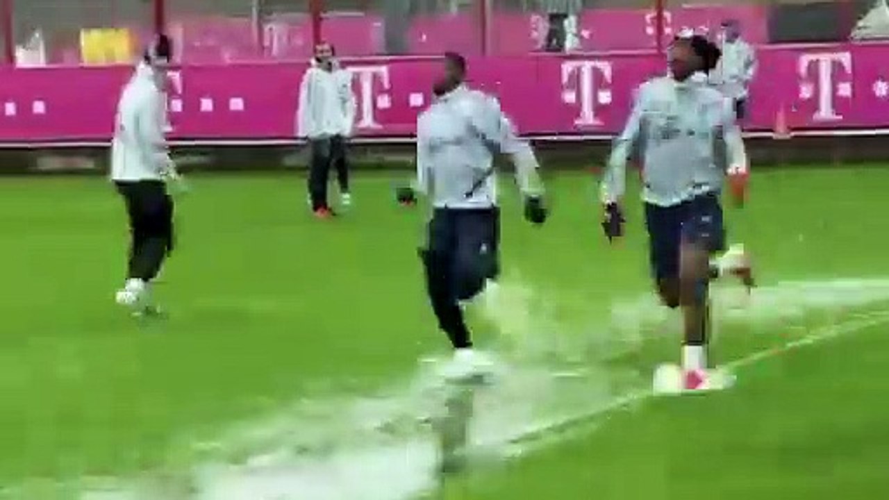 Football - Bayern Munich players sliding in water during training