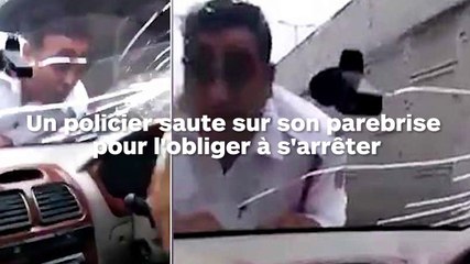 Le policier saute sur le parebrise pour arrêter l'automobiliste en fuite