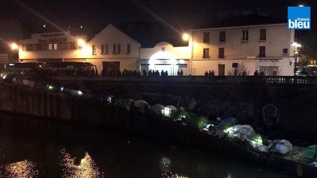 Évacués, des migrants refusent de descendre du bus qui les évacue.