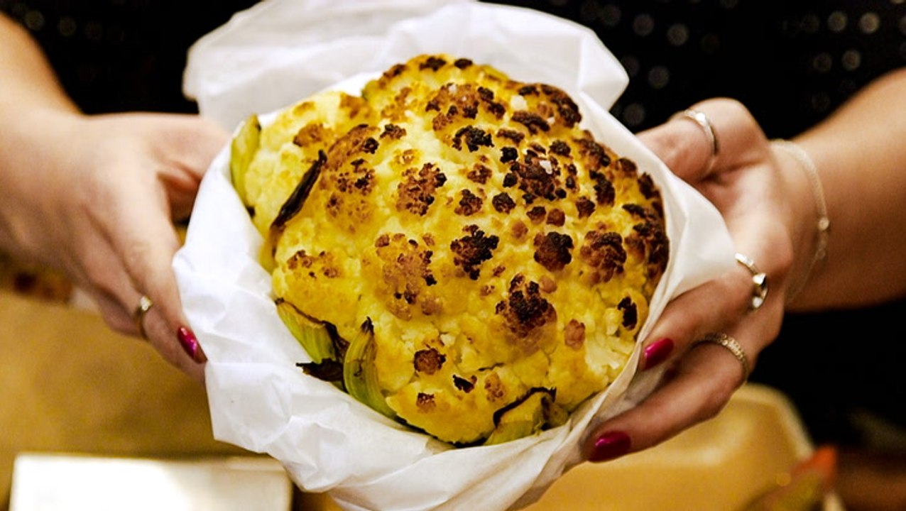 People line up inside NYC's Chelsea Market to try Israeli fast-casual chain Miznon's whole roasted cauliflower