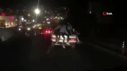 Seyir halindeki otomobilin bagajına oturan 3 kişi canlarını hiçe saydı