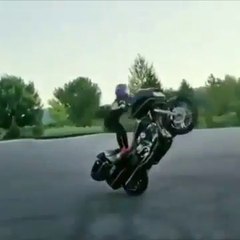 Cette fille toute mince fait un wheeling avec une énorme moto... Joli