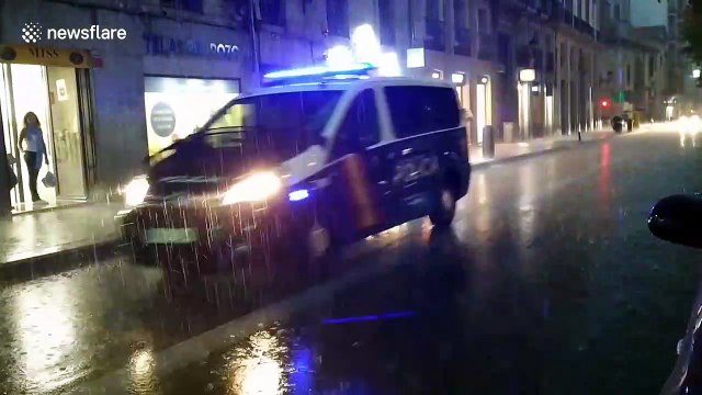 Road maintenance workers attempt to drain road after storm batters Madrid
