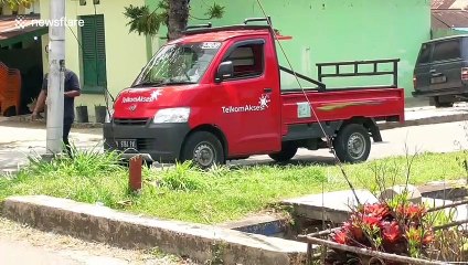 Bread truck fails to clear telephone lines and blocks traffic in Indonesia