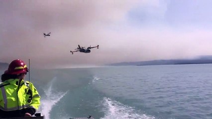 Un canadair fait le plein sur un lac