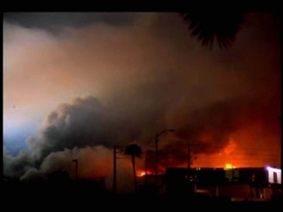 Wide shot Dunes HotelCasino imploding and falling with smoke