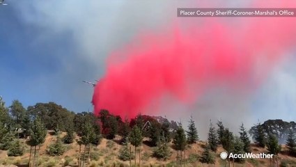 A plume of red retardant combats vegetation fire