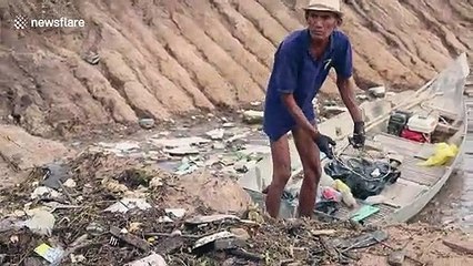 Cambodian grandfather hailed a hero for using his boat to collect piles of rubbish in a lake