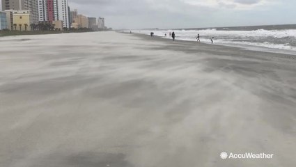 Flying sand and rough waves make for a less-than-perfect beach day