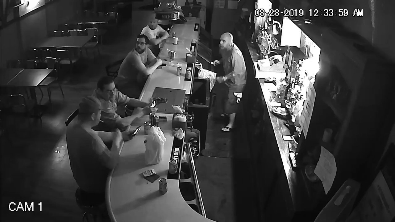 Un homme continue calmement de fumer et de consulter son téléphone pendant un vol à main armée