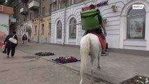 Na Rússia, entregador leva comida montado em um cavalo branco