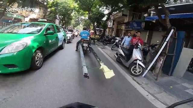 Man transports huge metal rods through Vietnam streets on motorbike