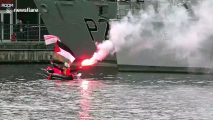 Activists in a CANOE breach London DSEi arms fair security waving Palestinian flag