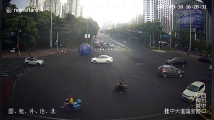 Strong wind blows giant moon-themed balloon onto busy Chinese road
