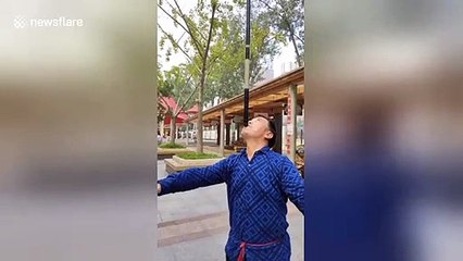 Chinese man spins diablo on the end of fishing rod balanced on his mouth