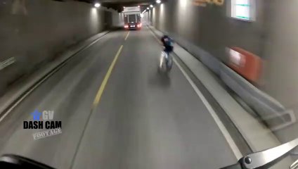 Ce cycliste trébuche et finit au milieu de la route face à un camion