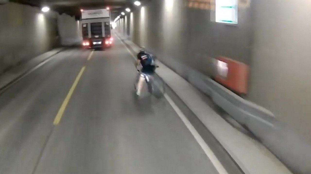 Un cycliste percute une barrière et tombe sur la route juste devant un camion