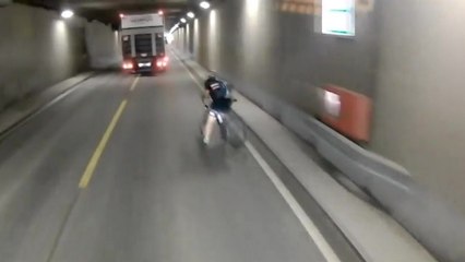Un cycliste percute une barrière et tombe sur la route juste devant un camion