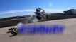 Un motard en train de faire un wheeling décolle dans les airs en roulant sur la moto de son pote