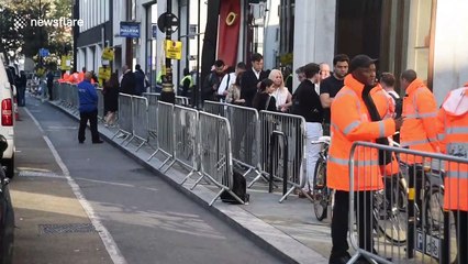 Customers depart Apple stores in London with new iPhones in hand