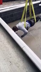 Suspendu dans les airs, cet ouvrier termine une dalle de béton