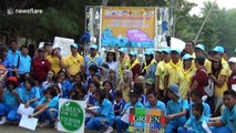 Schoolchildren help to clean rubbish from polluted beach in southern Thailand