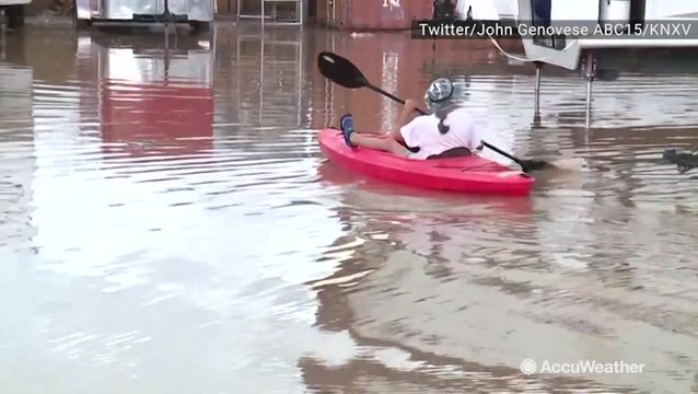 Man kayaks through flooded roads