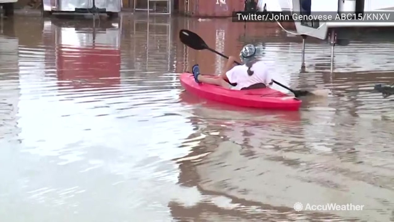 Man kayaks through flooded roads