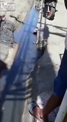 Il plonge dans un caniveau sans fond pour le nettoyer ! En pleine rue !