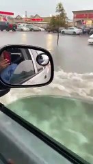 Il roule dans sa ville inondée au milieu des voitures noyées