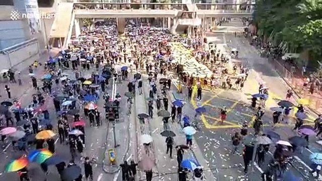 Hong Kong protesters chant “Five demands, not one less” during protest in Wan Chai