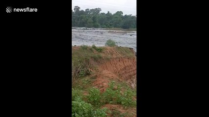 Dramatic moment river changes course and plunges into huge coal mine in India